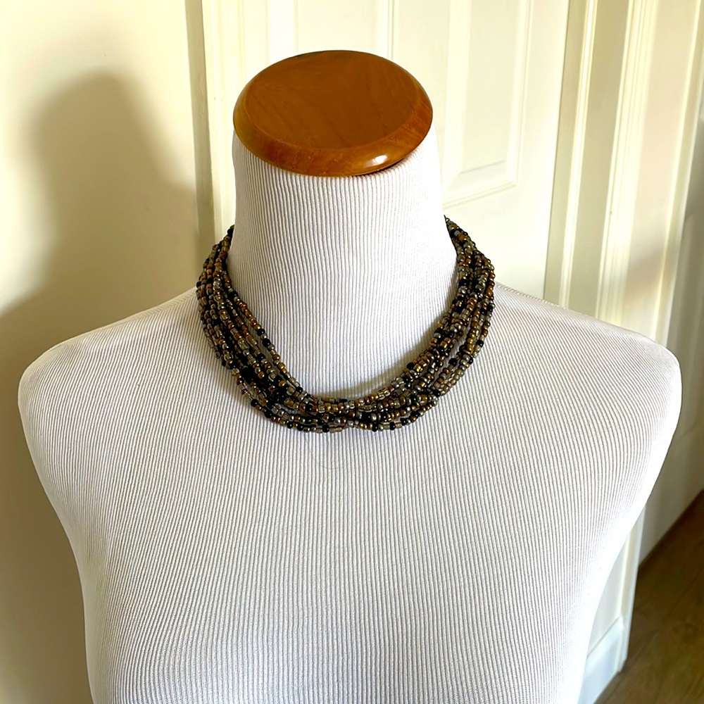 Neutral colors brown black and gray seed bead necklace with a  button closure.